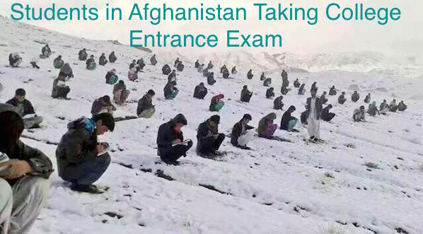 Rows of students sitting in the snow, writing on test booklets, with the caption, ''Students in Afghanistan taking college entrance exam.''